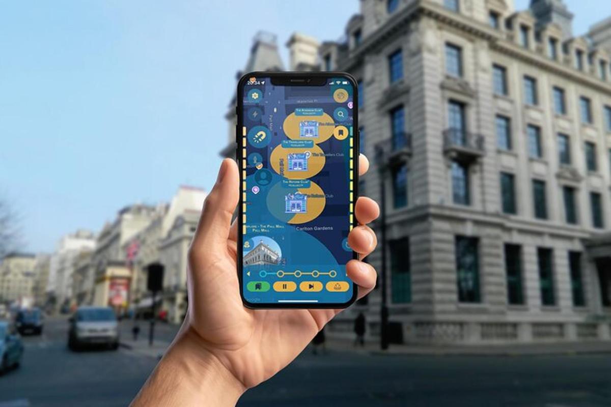 ruka držící mobilní telefon před budovou