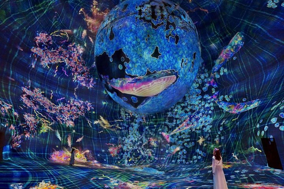 a woman standing in front of a painting of the earth