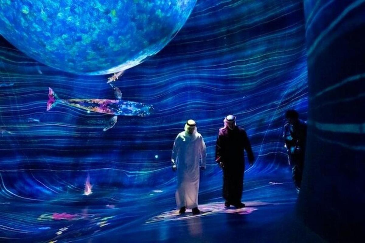 two people standing on a stage looking at the ocean