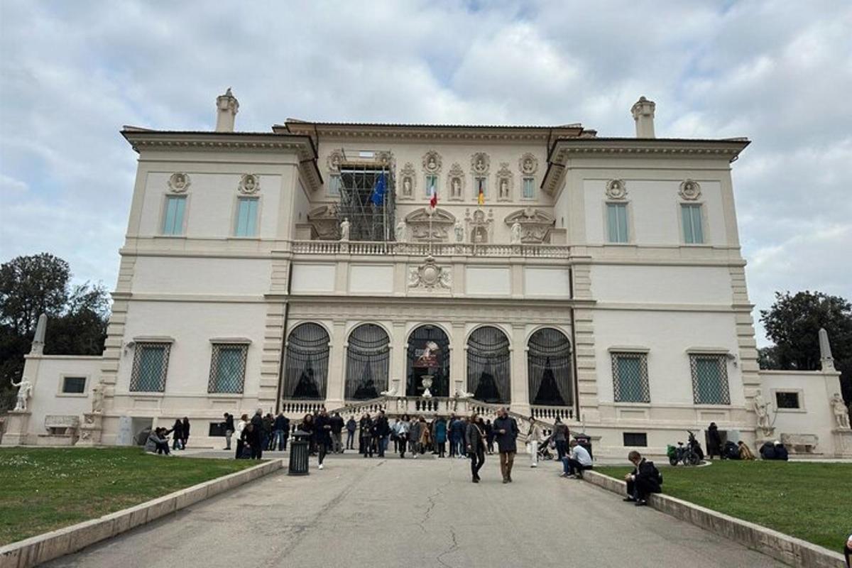 a large white building with people walking in front of it