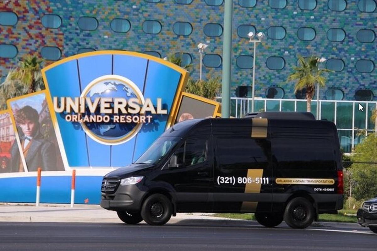 Una camioneta negra está estacionada frente a un cartel