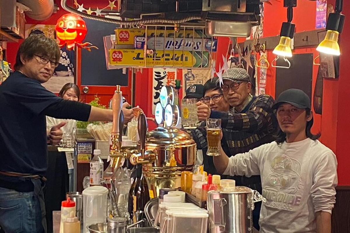 skupina lidí stojících kolem baru s barmanem