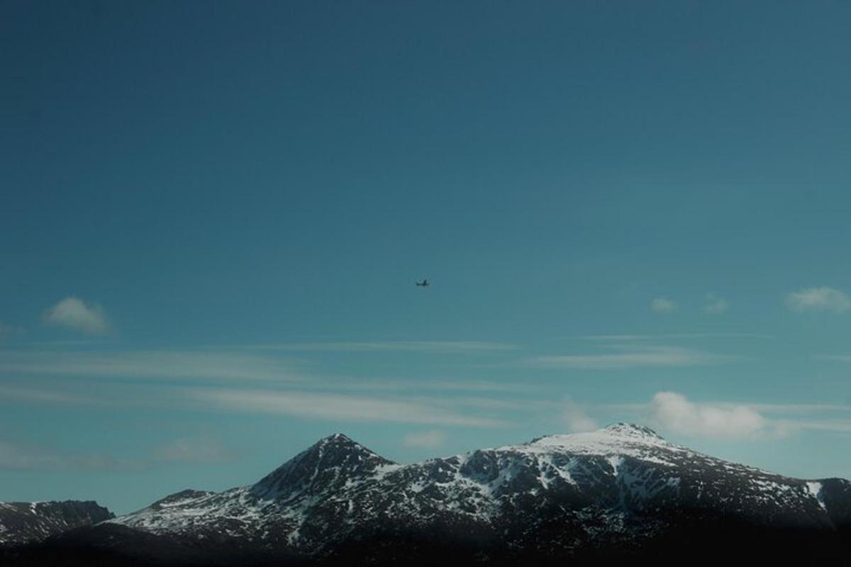a mountain range with snow on it with a sky