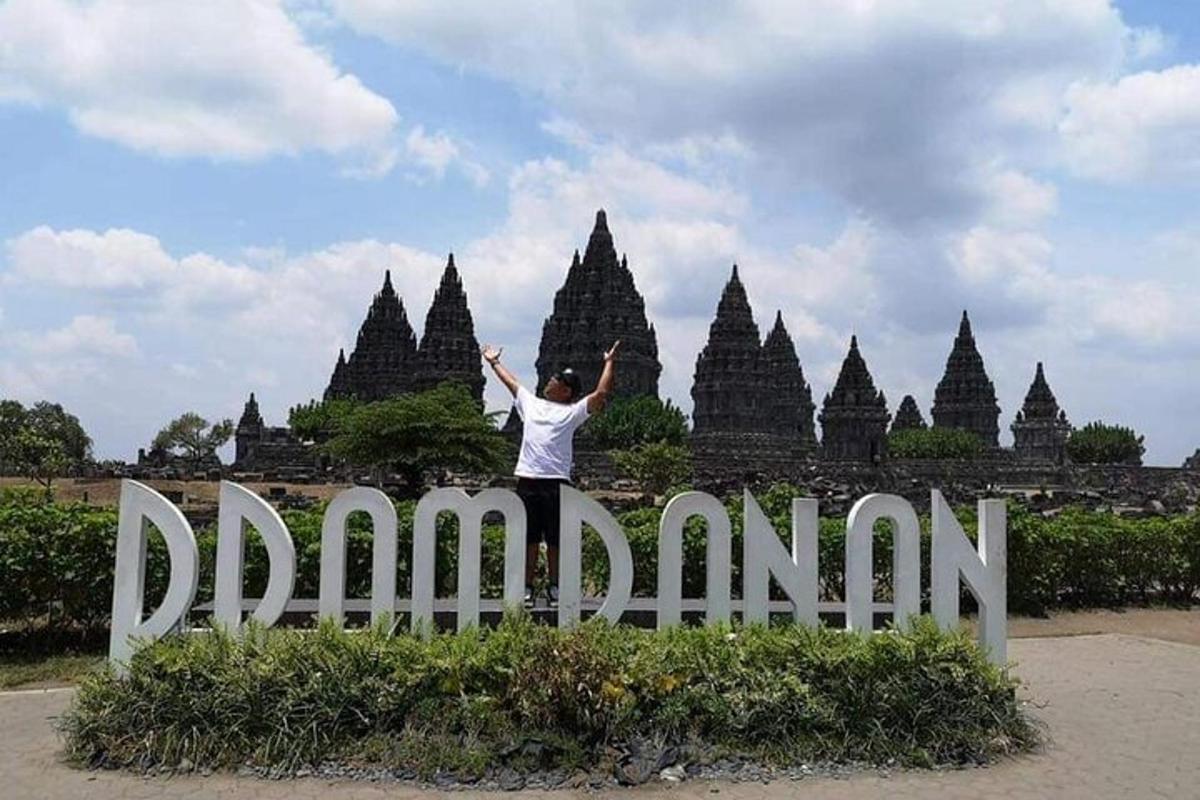 a person standing on top of a sign in front of a temple