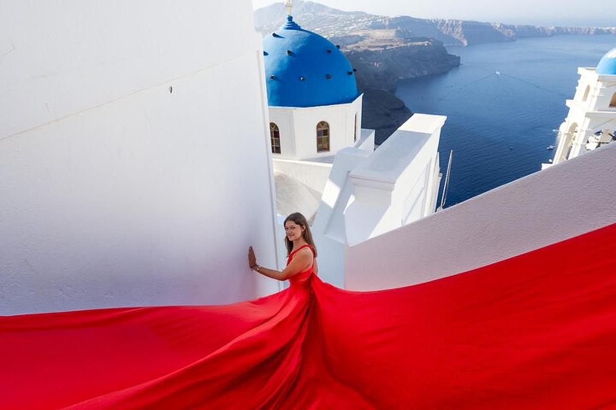 Μια γυναίκα με κόκκινο φόρεμα που στέκεται πάνω σε ένα λευκό κτίριο
