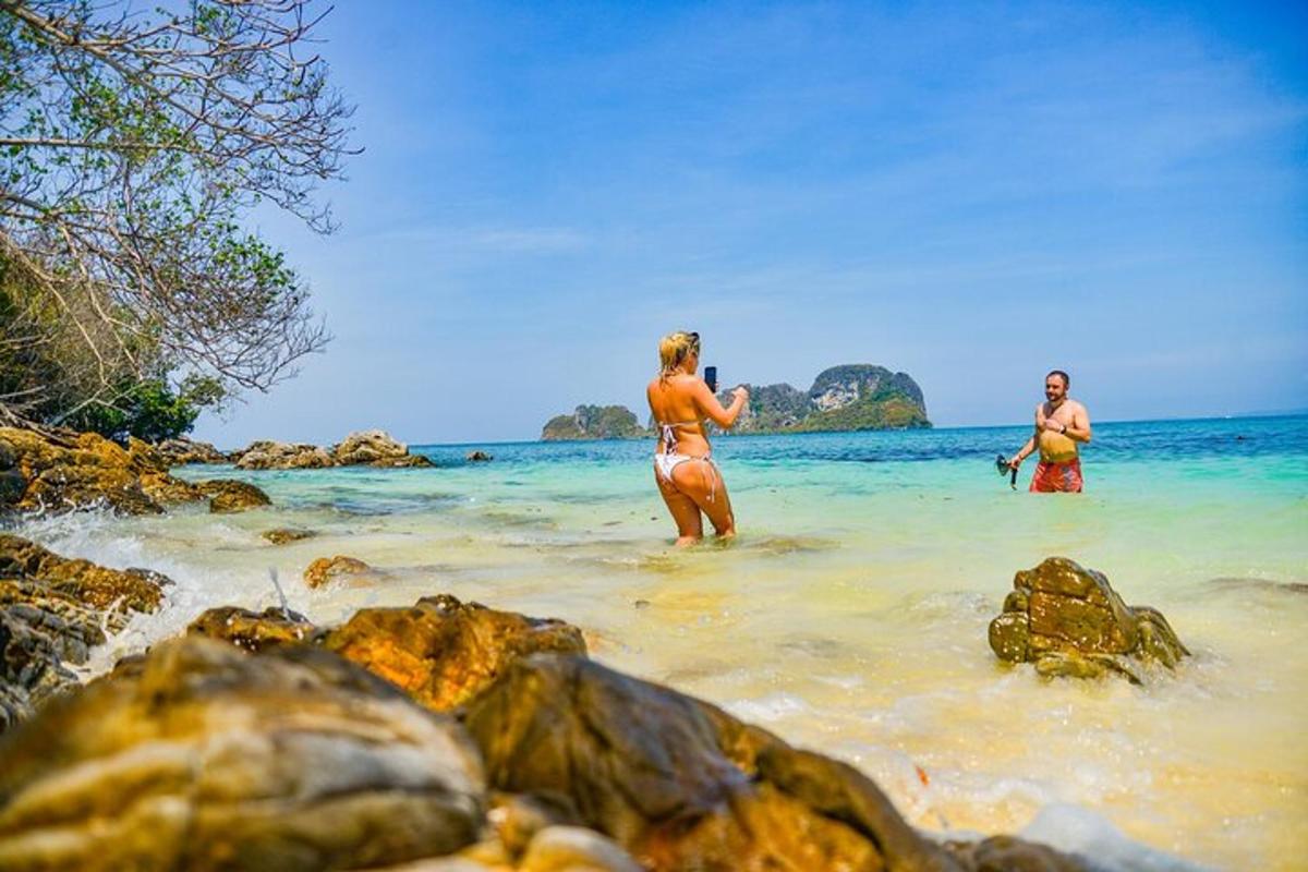 duas pessoas em pé na água em uma praia