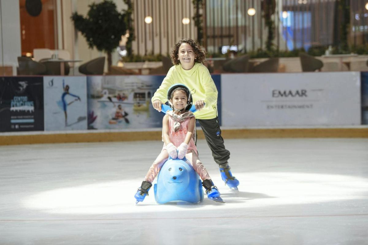 a couple of girls skating on an ice rink