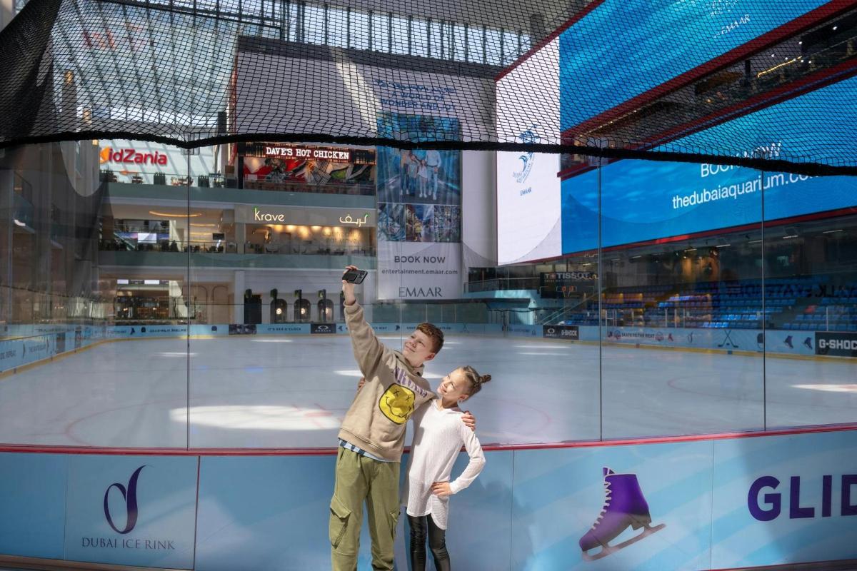 a man and a woman standing on an ice rink