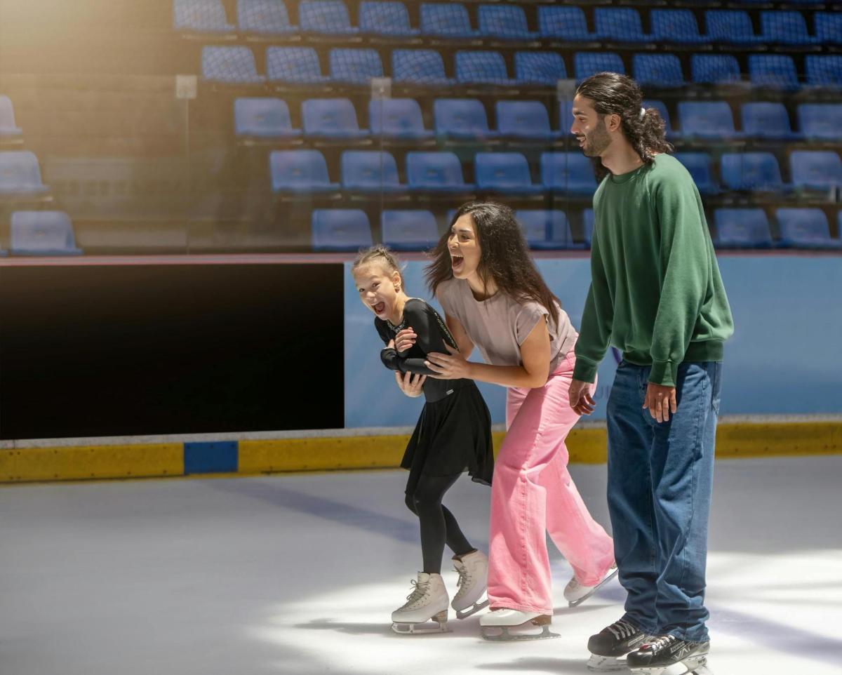 a woman and a man and a child on the ice