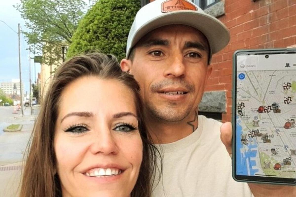 Un hombre y una mujer sosteniendo un teléfono celular