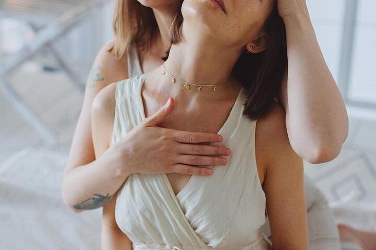 uma mulher de vestido branco segurando a barriga