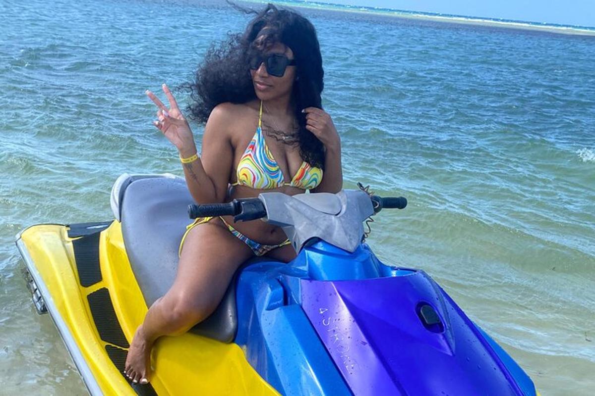 Egy bikiniben lévő nő jetski-n ül a vízen