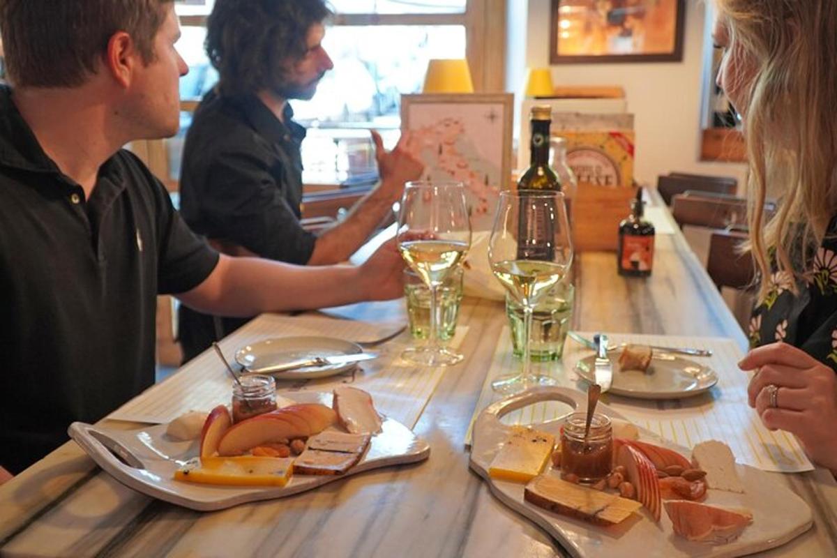 Un grupo de personas sentadas en una mesa con comida y vino.