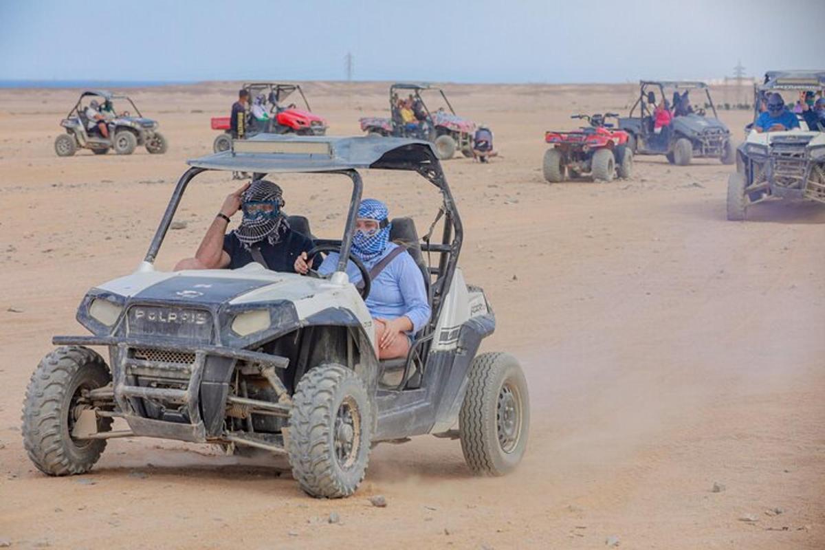 due persone in sella a un quad nel deserto