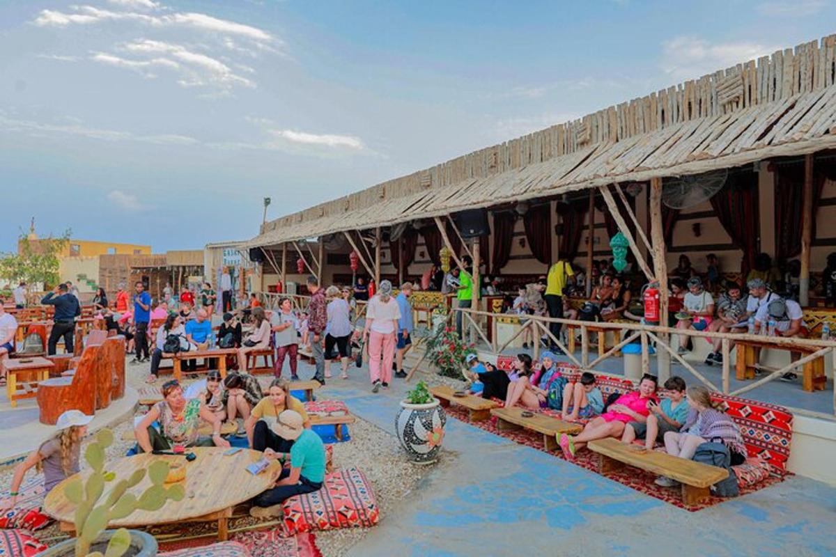 un folto gruppo di persone sedute su panchine su una spiaggia