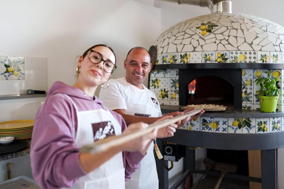 een man en een vrouw staan voor een pizzaoven