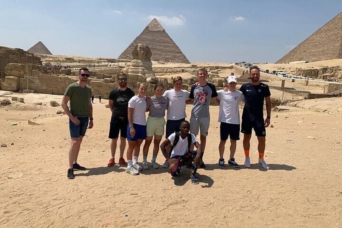 a group of people standing in front of the pyramids