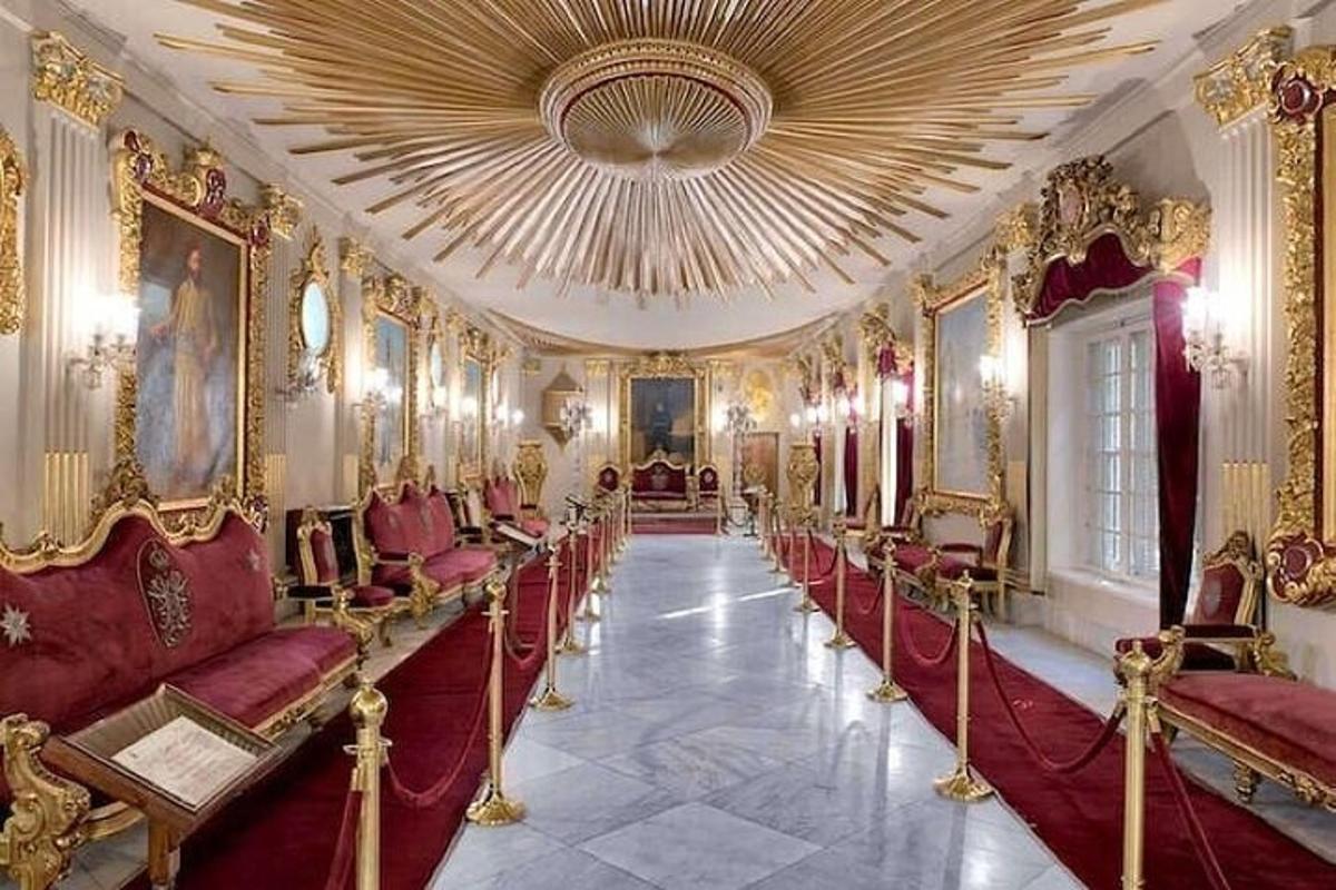 Una habitación con sillas rojas y un techo grande.