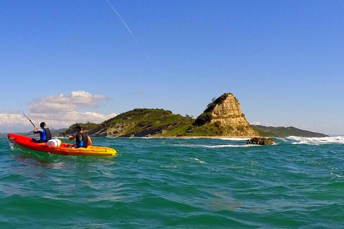 hai người trên một chiếc thuyền kayak trên đại dương với một hòn đảo