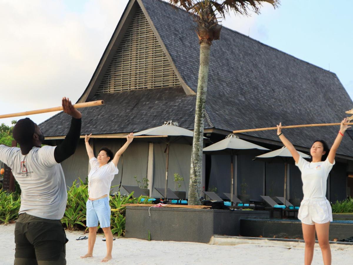 一群人站在海滩上，高举双臂