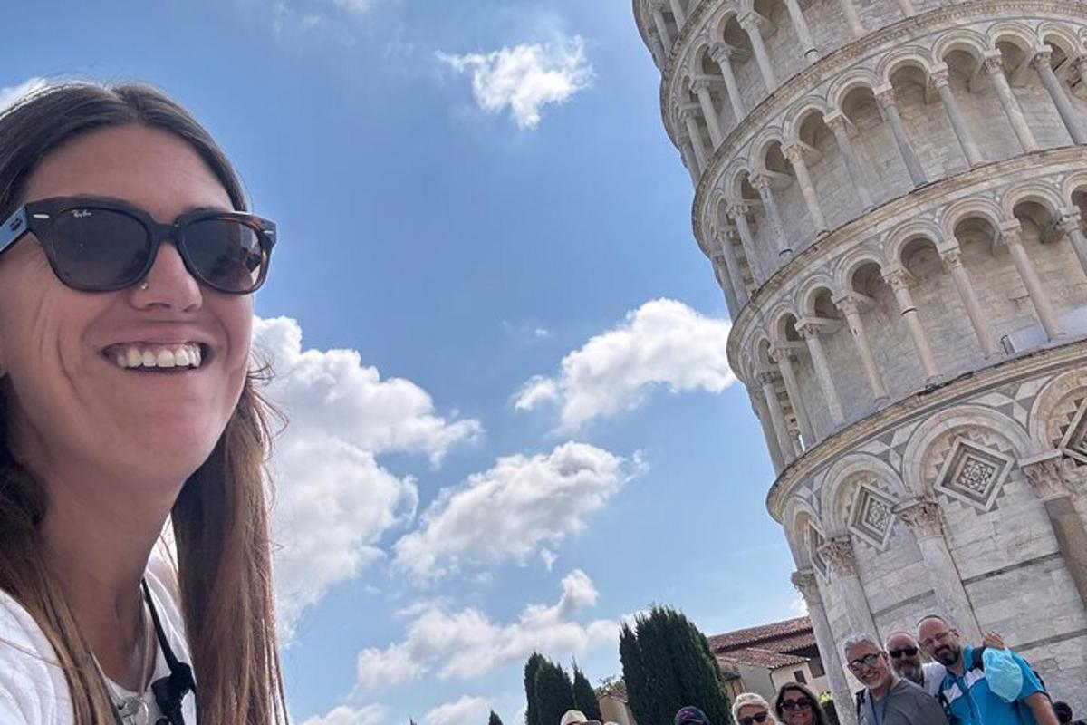 isang babaeng nakasuot ng sunglasses na nakatayo sa harap ng leaning tower