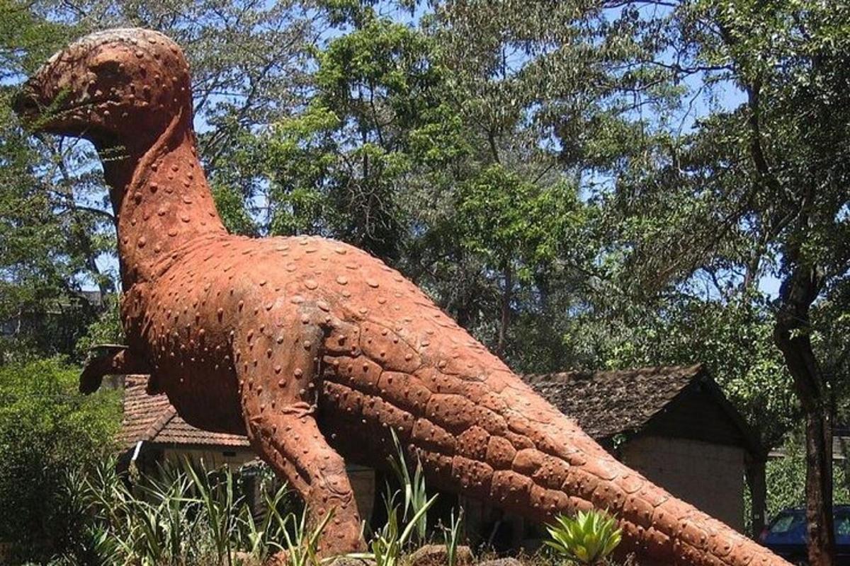 uma estátua de uma galinha sentada na grama