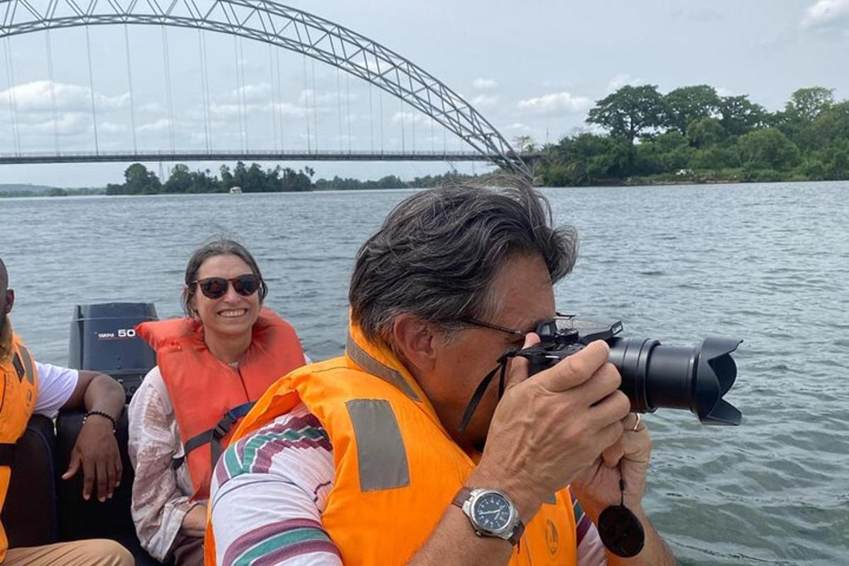 seorang pria mengambil gambar di atas perahu dengan kamera