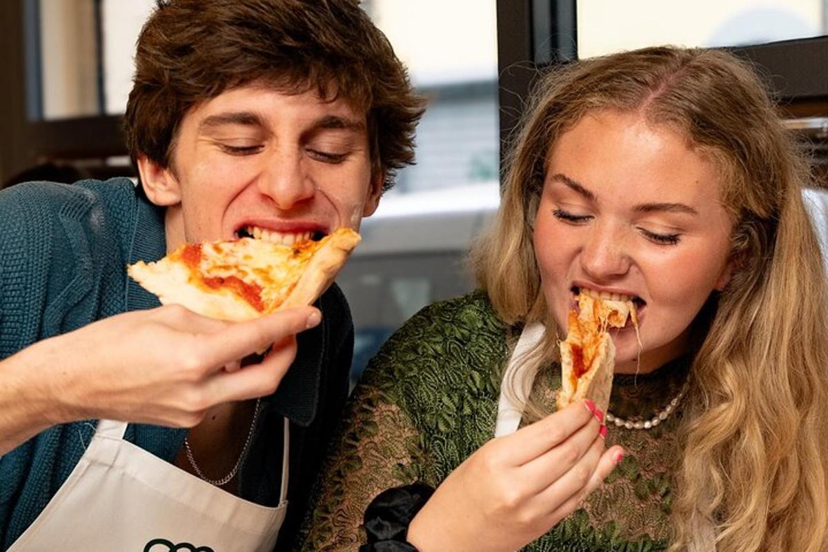 um homem e uma mulher comendo uma fatia de pizza