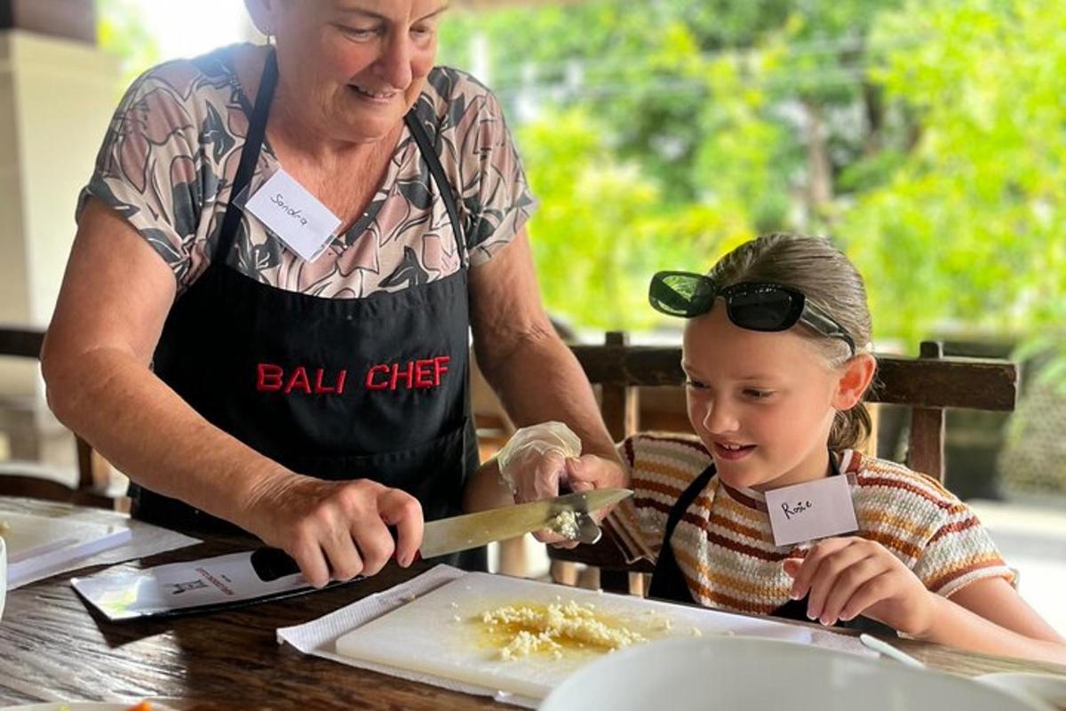 žena učí malou holčičku, jak připravovat jídlo