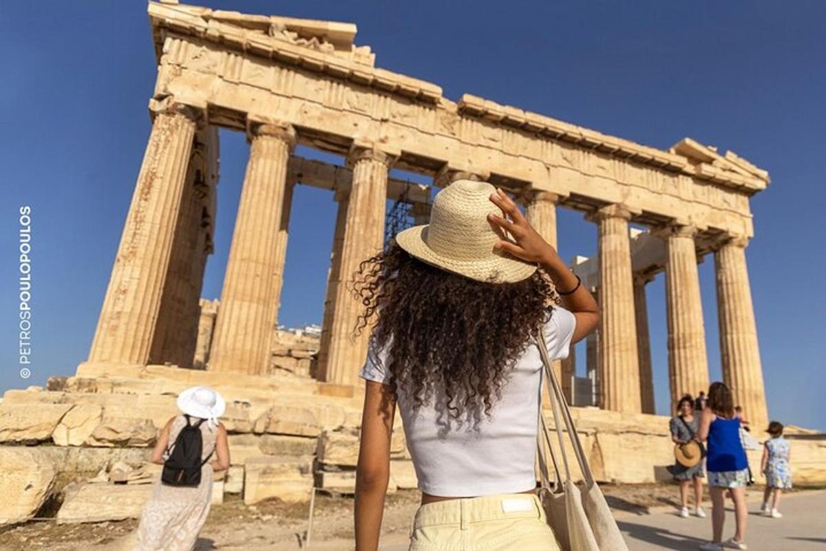 Una mujer con sombrero parada frente a un templo.