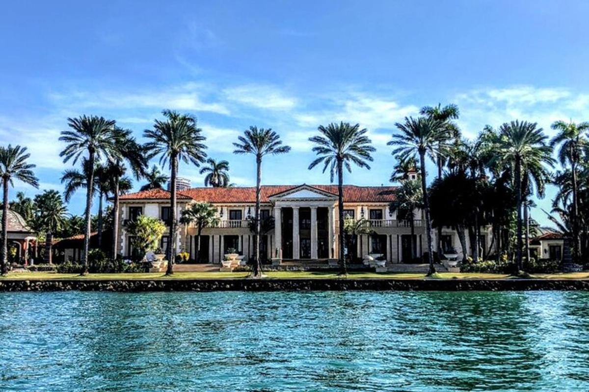 una casa con palme di fronte a uno specchio d'acqua