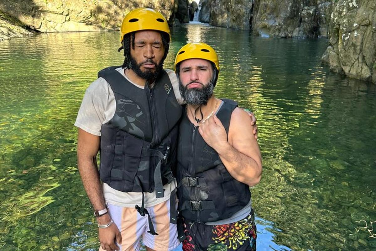 two men wearing hard hats standing in the water
