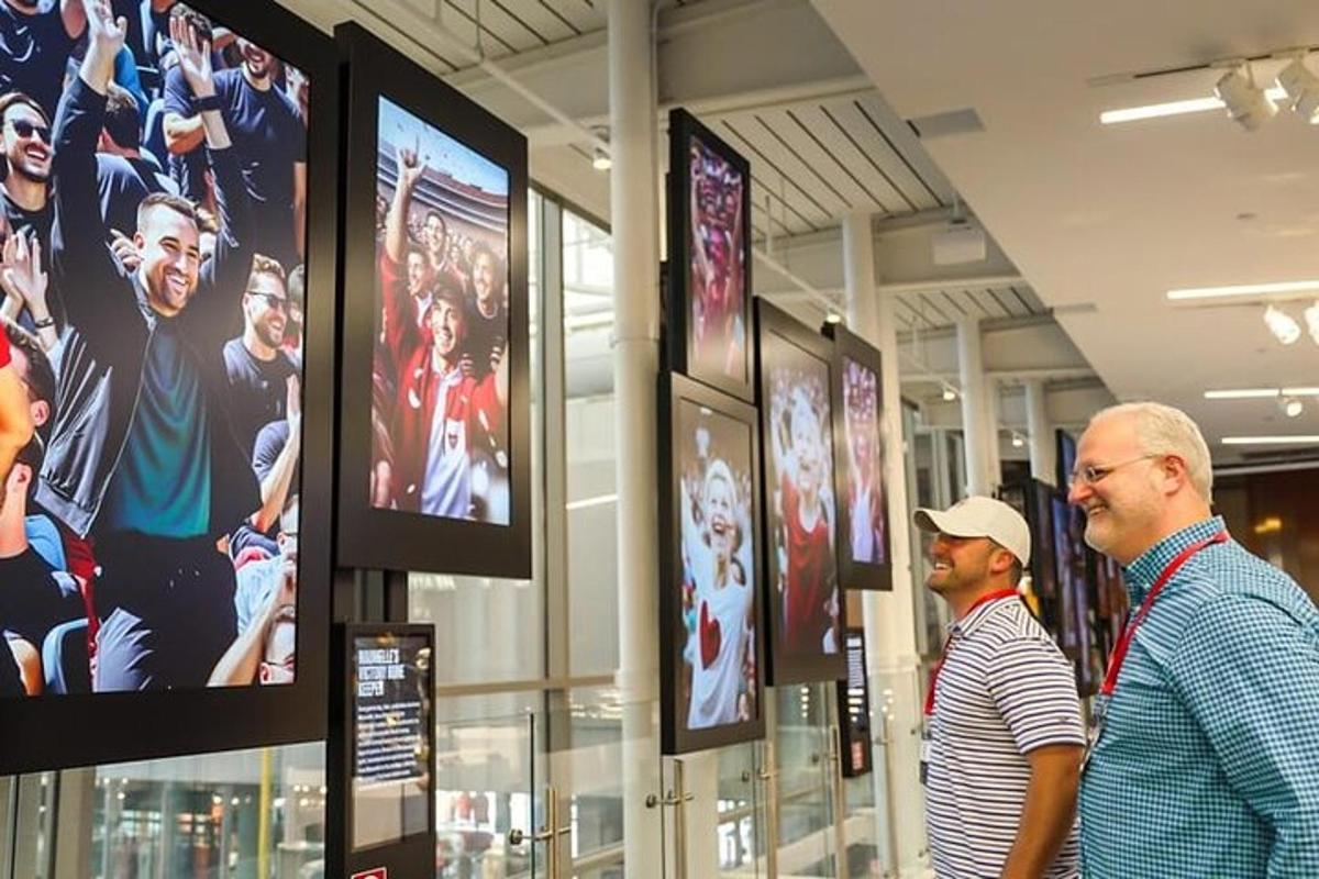 two men standing in a store looking at video screens