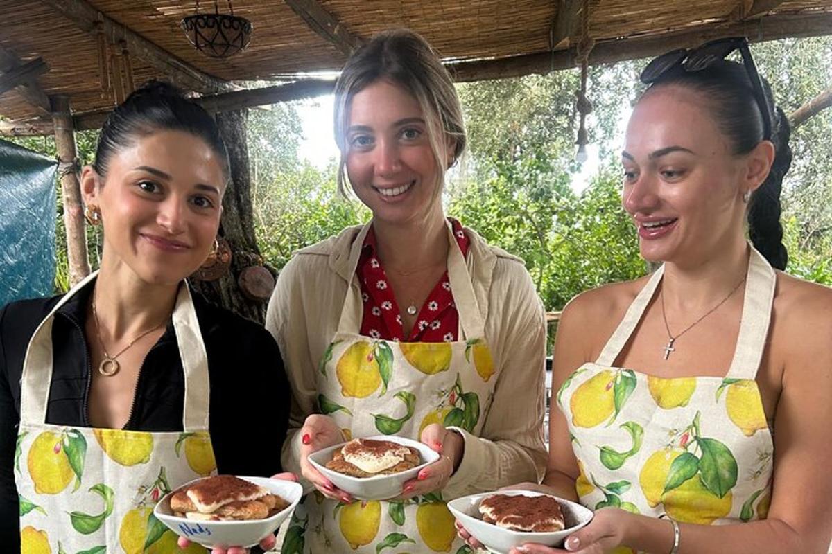 drei Frauen in Schürzen halten Schüsseln mit Essen