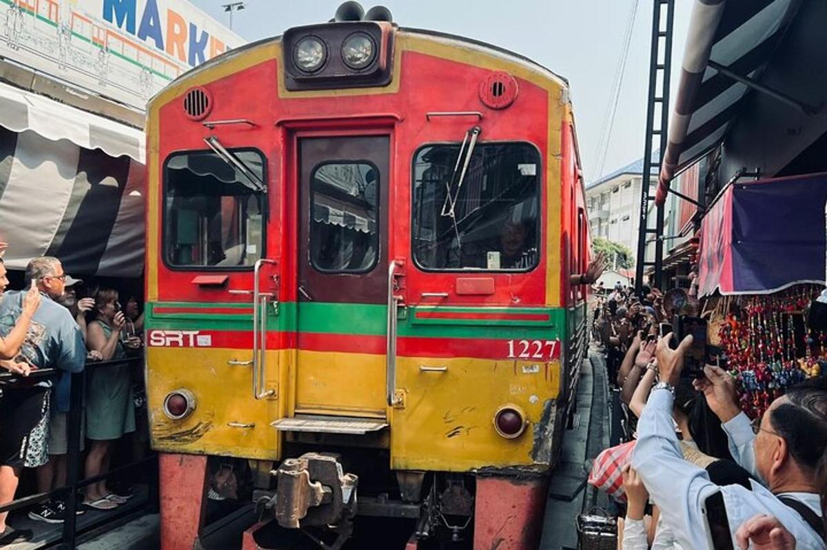 uma multidão de pessoas está tirando fotos de um trem