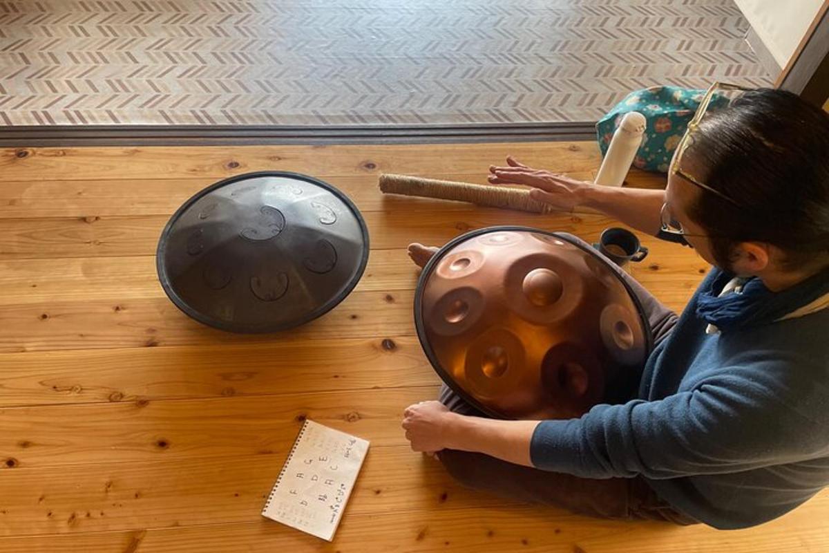 一位女士坐在地板上，旁边是一个金属球