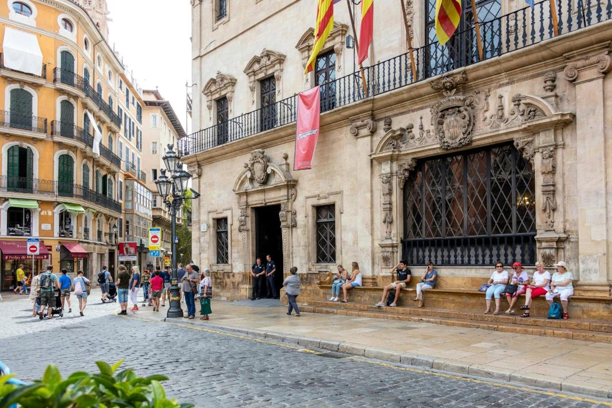un gruppo di persone sedute su una panchina fuori da un edificio