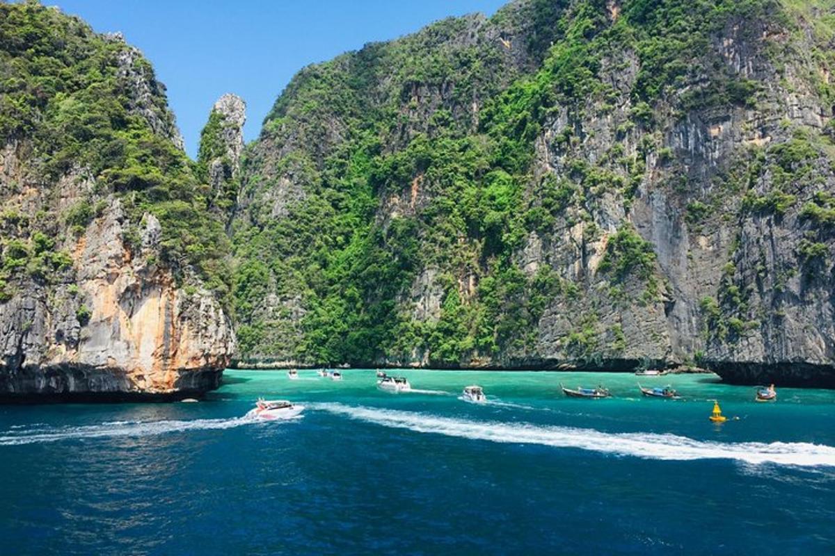 un gruppo di barche in acqua vicino alle scogliere