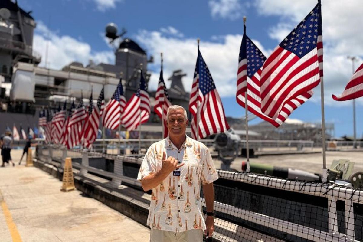 a man standing in front of a bunch of american flags
