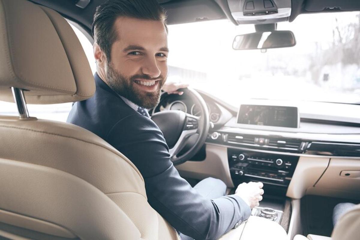 um homem sentado no banco do motorista de um carro