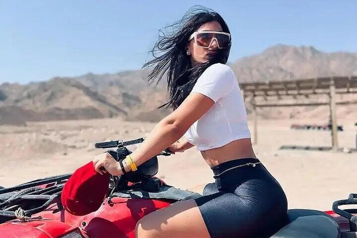 žena sedící na motorce v poušti