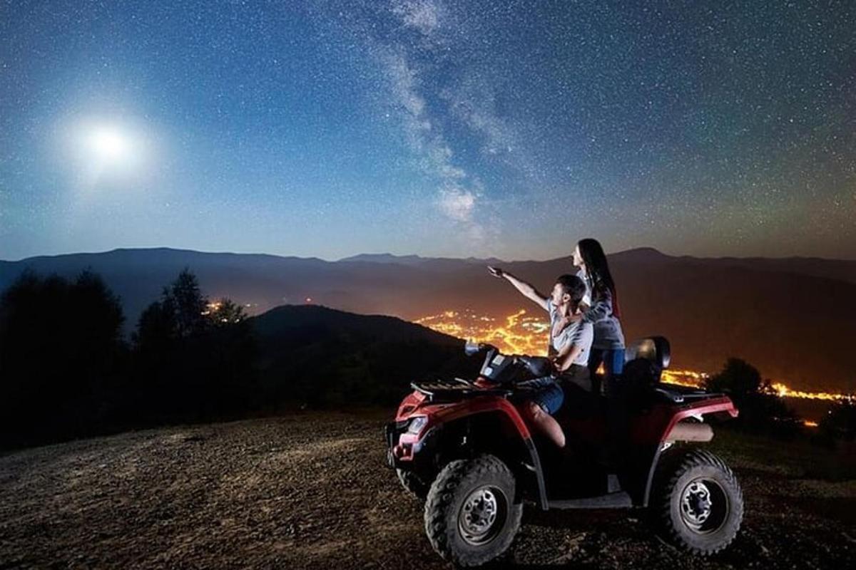 muž a žena sedící v noci na čtyřkolce