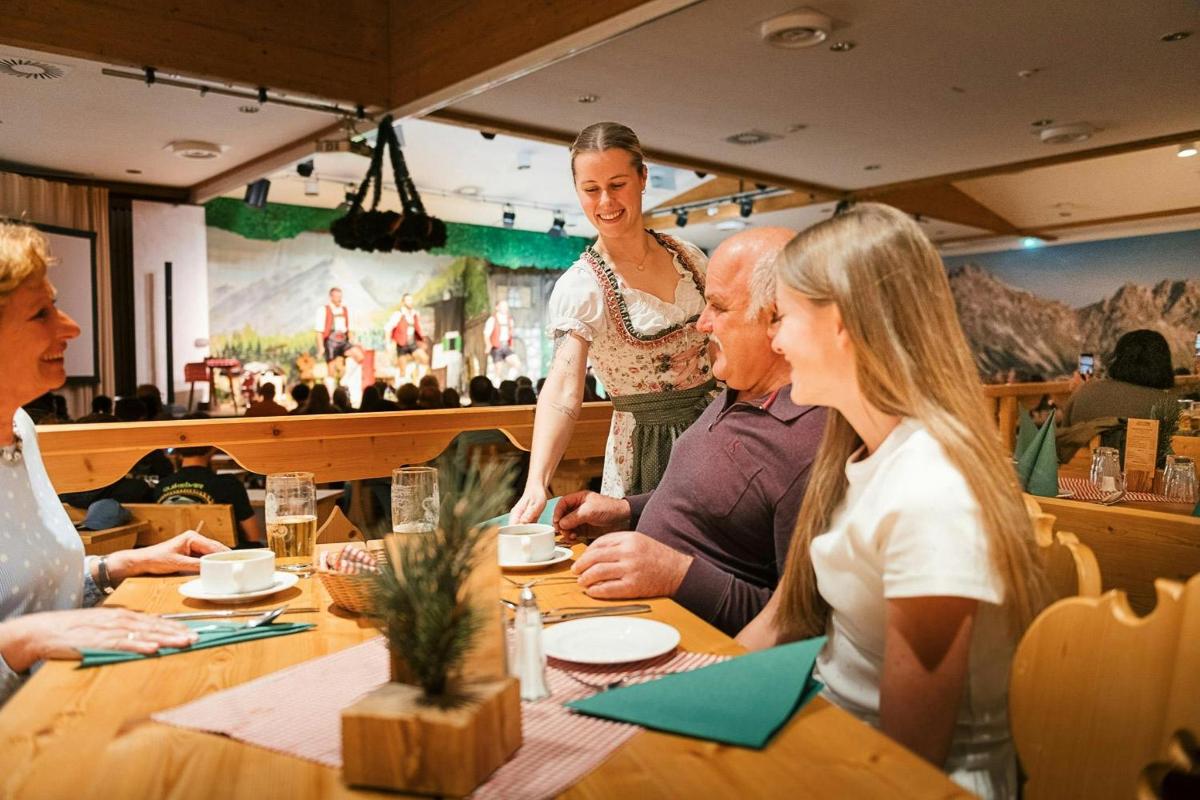 a group of people sitting around a table in a restaurant