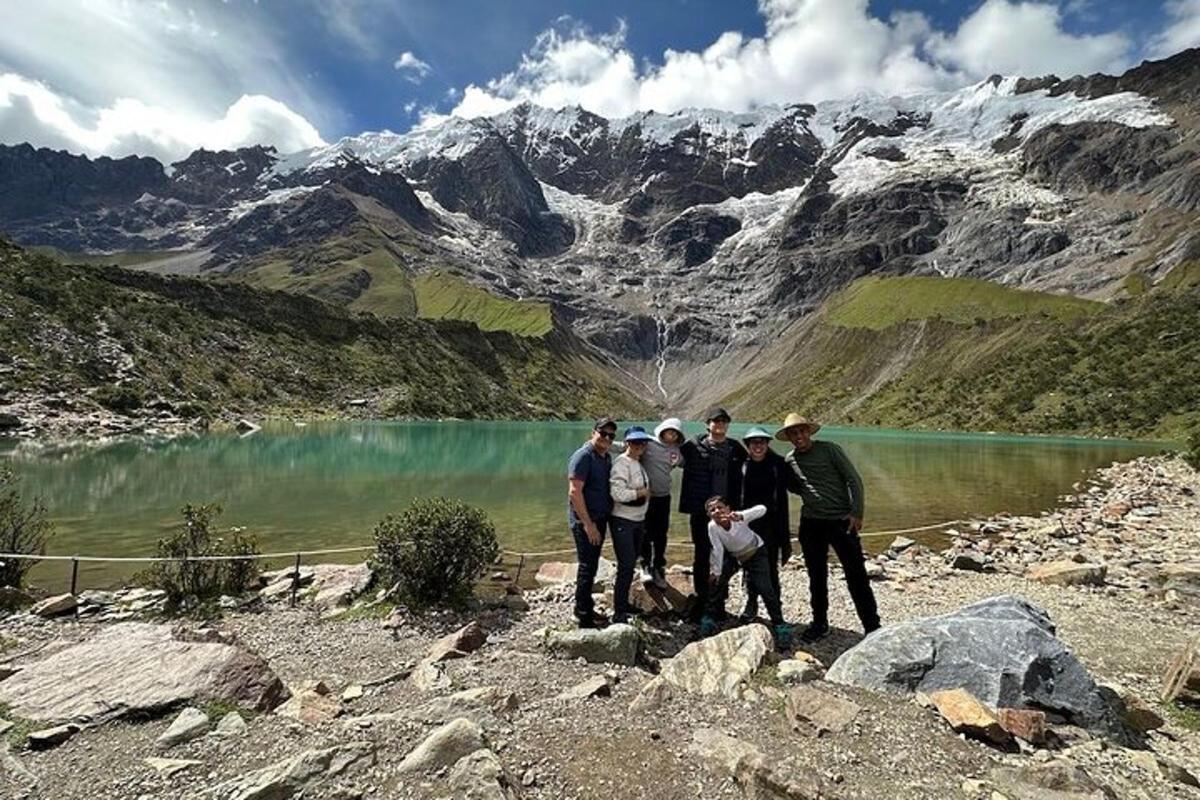 un gruppo di persone in piedi vicino a un lago di montagna