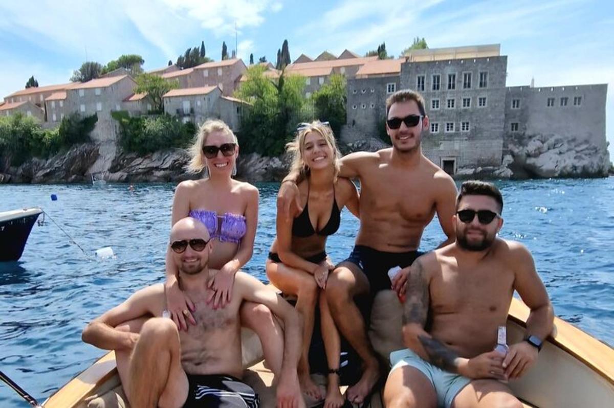 joukko ihmisiä istuu veneessä vedessä