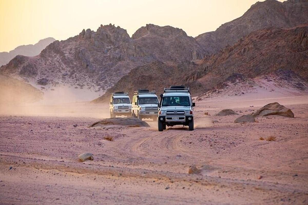 un gruppo di tre veicoli che guidano nel deserto