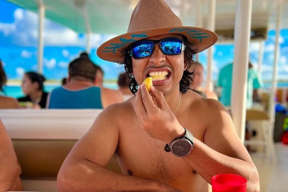 een man met een strooien hoed die een banaan eet