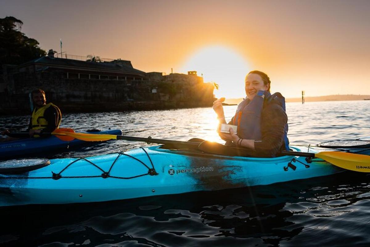 una donna in kayak sull'acqua al tramonto