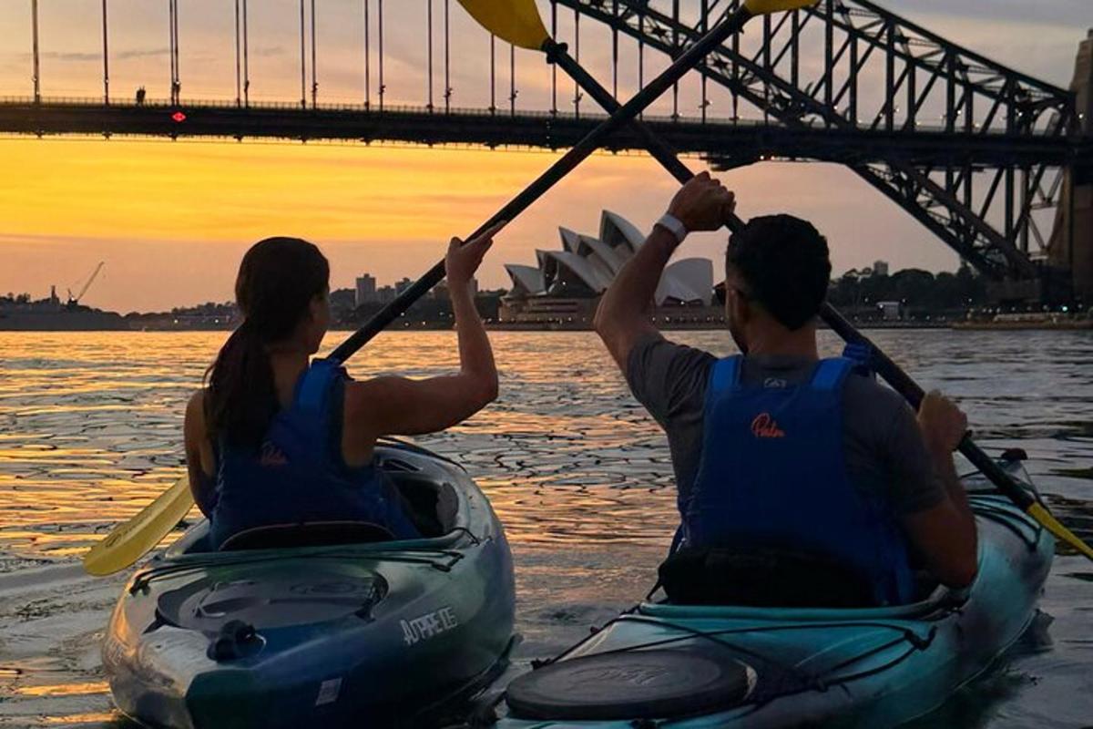 due persone in kayak sull'acqua davanti a un ponte