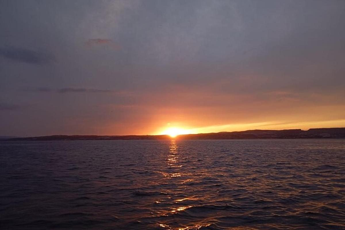 una puesta de sol sobre una gran masa de agua